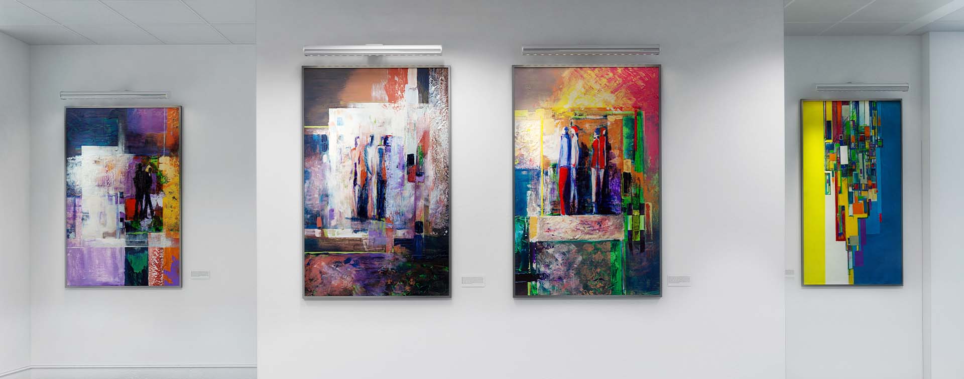 Four paintings hung on a gallery wall