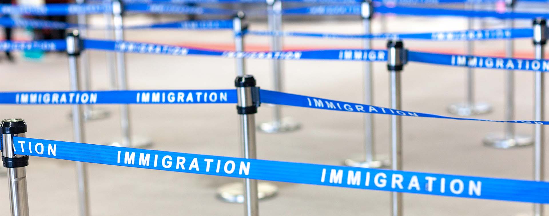 Woman dragging a suitcase looking out of a window at a plane taking off