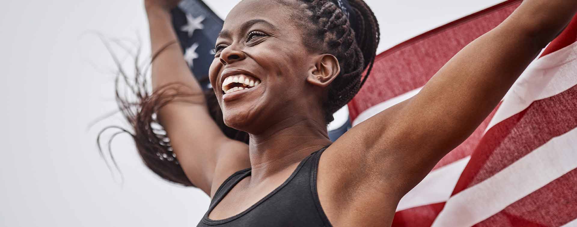 Female athlete holding up the flag of the United States of America
