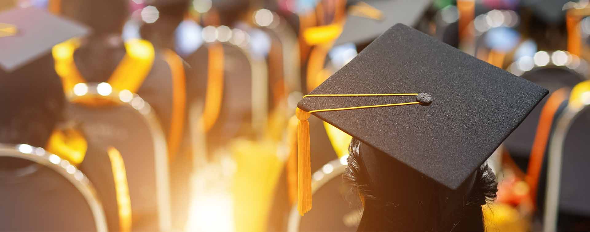 University students at graduation with bright backlighting