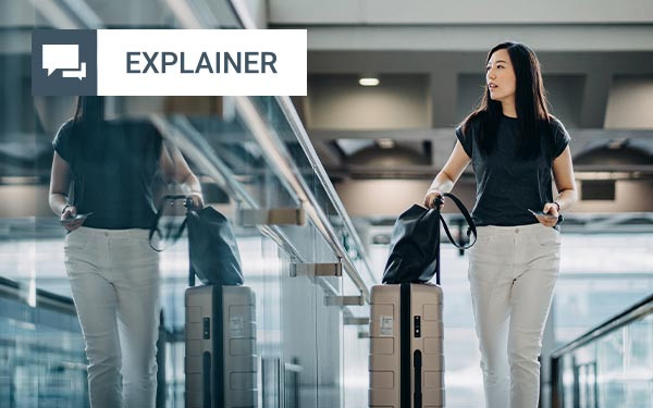 Woman with luggage walking through an airport terminal