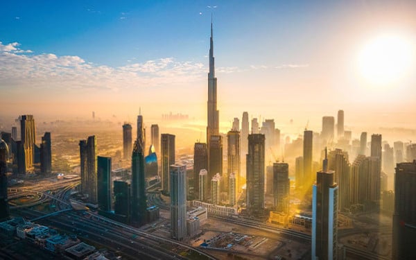 Dubai skyline with the Burj Khalifa in the center and sunshine spreading between the buildings