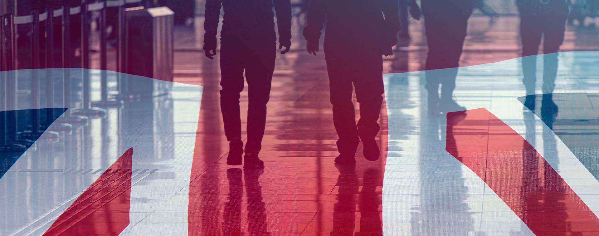 The UK flag overlaid on people walking through an airport terminal